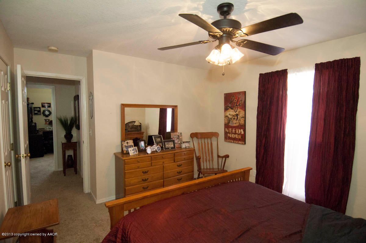 5402 Leo Lane Amarillo, TX 79110 - Photo 27 of 37 a bedroom with a bed and a chandelier