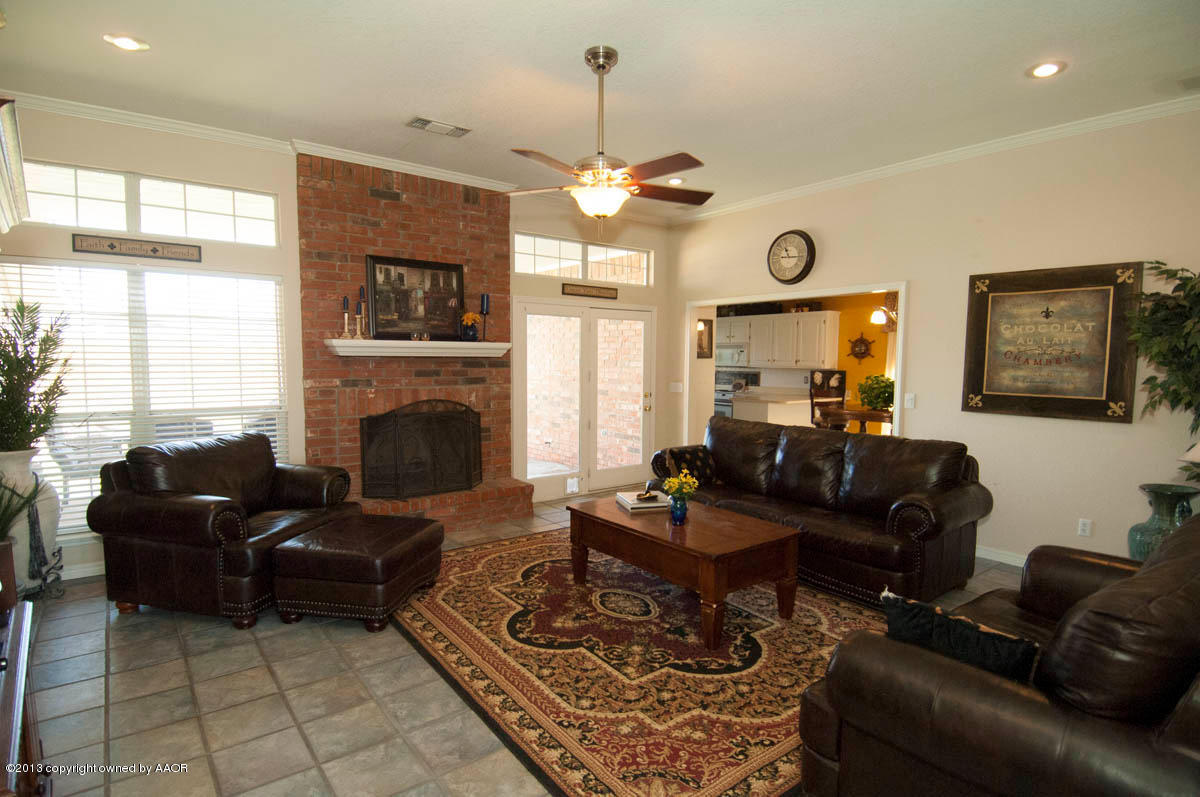 5402 Leo Lane Amarillo, TX 79110 - Photo 5 of 37 a living room with furniture a chandelier and a fireplace