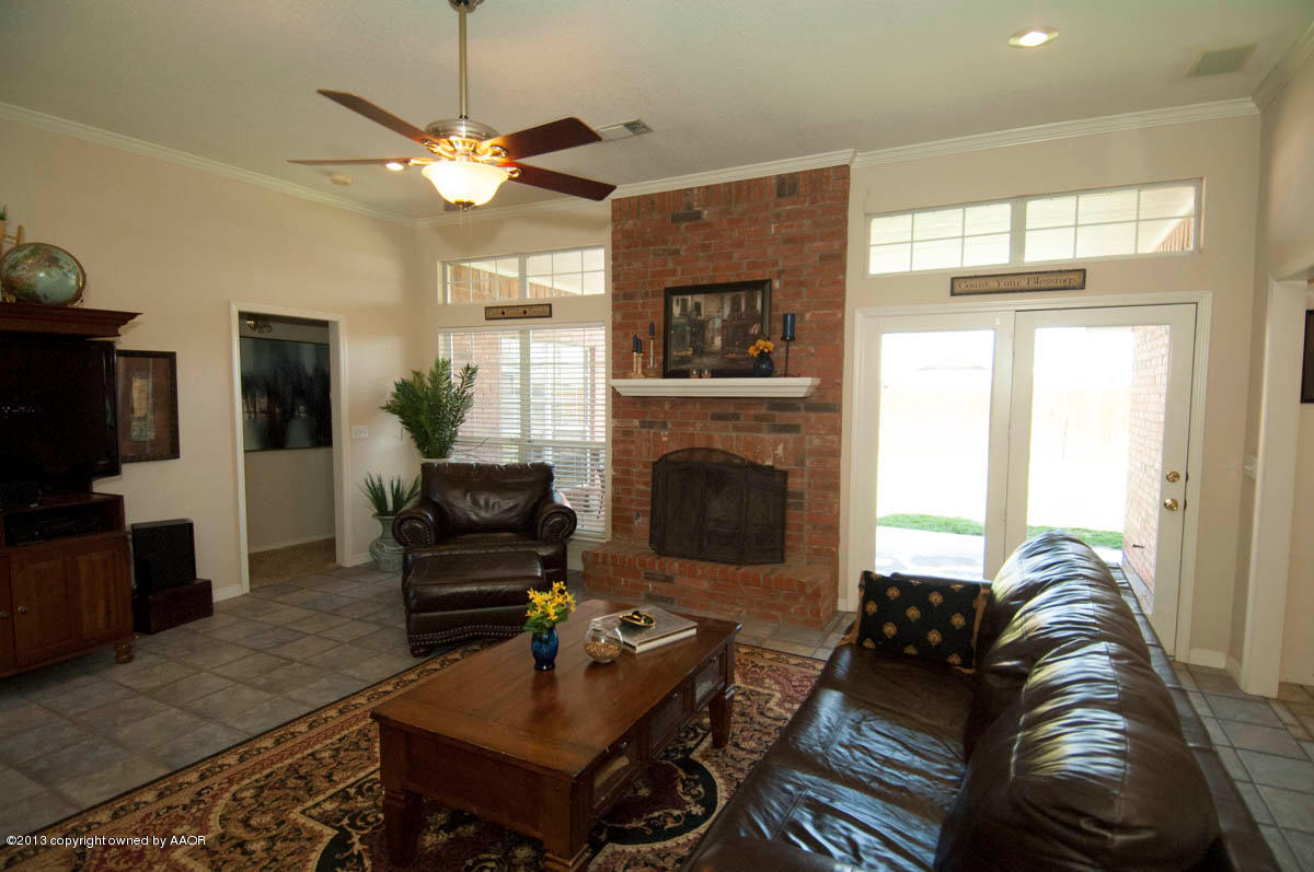 5402 Leo Lane Amarillo, TX 79110 - Photo 6 of 37 a living room with furniture a flat screen tv and a fireplace