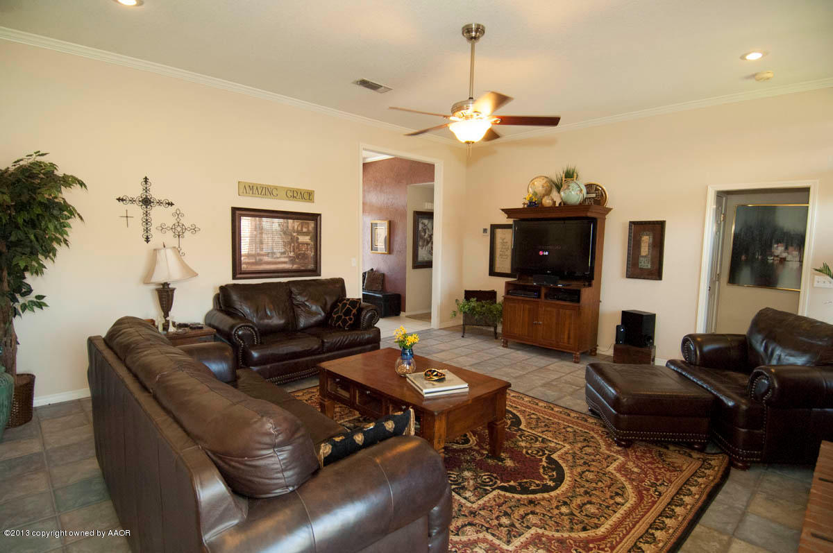 5402 Leo Lane Amarillo, TX 79110 - Photo 8 of 37 a living room with furniture a chandelier and a flat screen tv