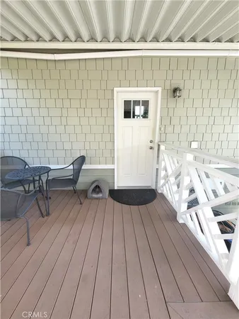 a view of a balcony with chairs and wooden floor