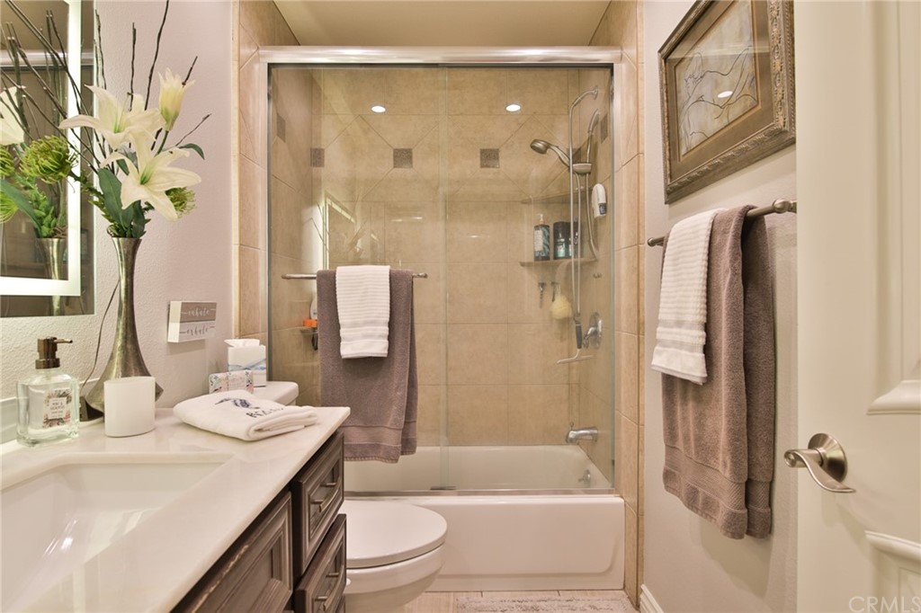38 Racing Wind Irvine, CA 92614 - Photo 27 of 56 a bathroom with a sink a toilet a mirror a bathtub and shower
