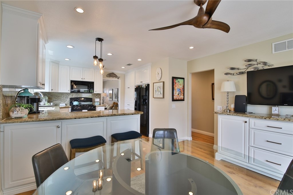 38 Racing Wind Irvine, CA 92614 - Photo 33 of 56 a kitchen with stainless steel appliances kitchen island granite countertop a sink a stove a dining table and chairs