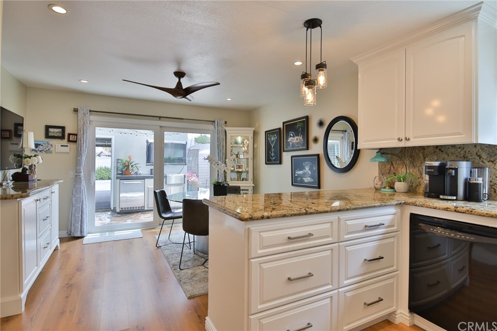 38 Racing Wind Irvine, CA 92614 - Photo 10 of 56 a dining hall with stainless steel appliances granite countertop a stove a sink dishwasher a dining table and chairs with wooden floor