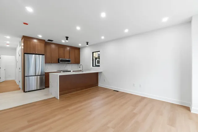 a large kitchen with a sink and stainless steel appliances