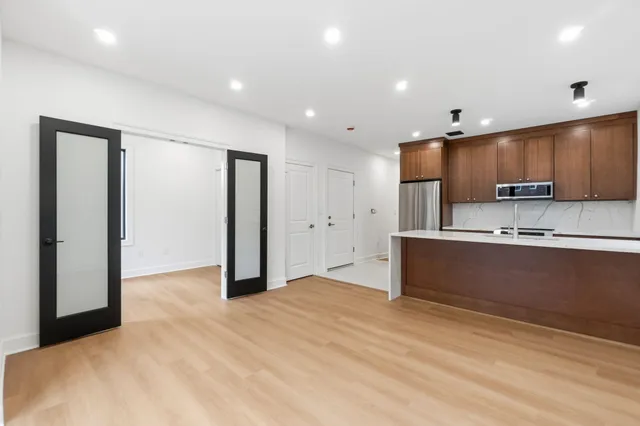 a kitchen with stainless steel appliances kitchen island granite countertop a refrigerator and a sink