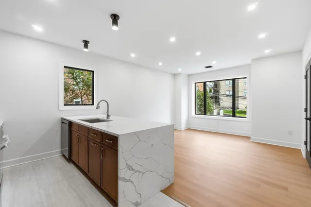 an empty room with wooden floor and window