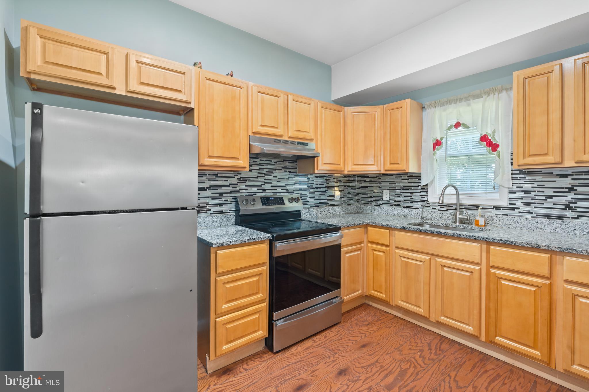 4400 6th Street Baltimore, MD 21225 - Photo 12 of 45 a kitchen with stainless steel appliances granite countertop a refrigerator sink and cabinets