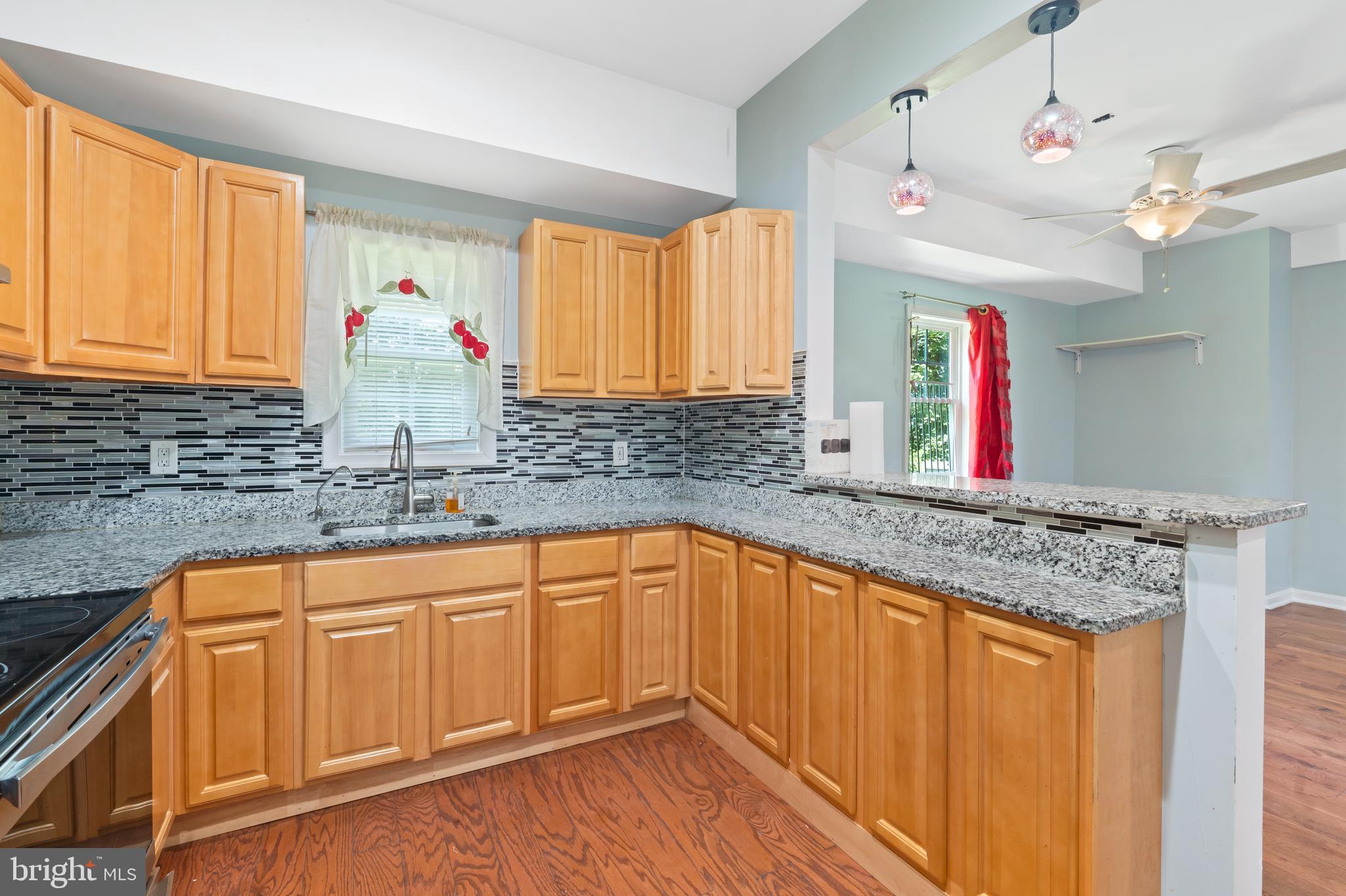 4400 6th Street Baltimore, MD 21225 - Photo 13 of 45 a kitchen with granite countertop a sink cabinets and window