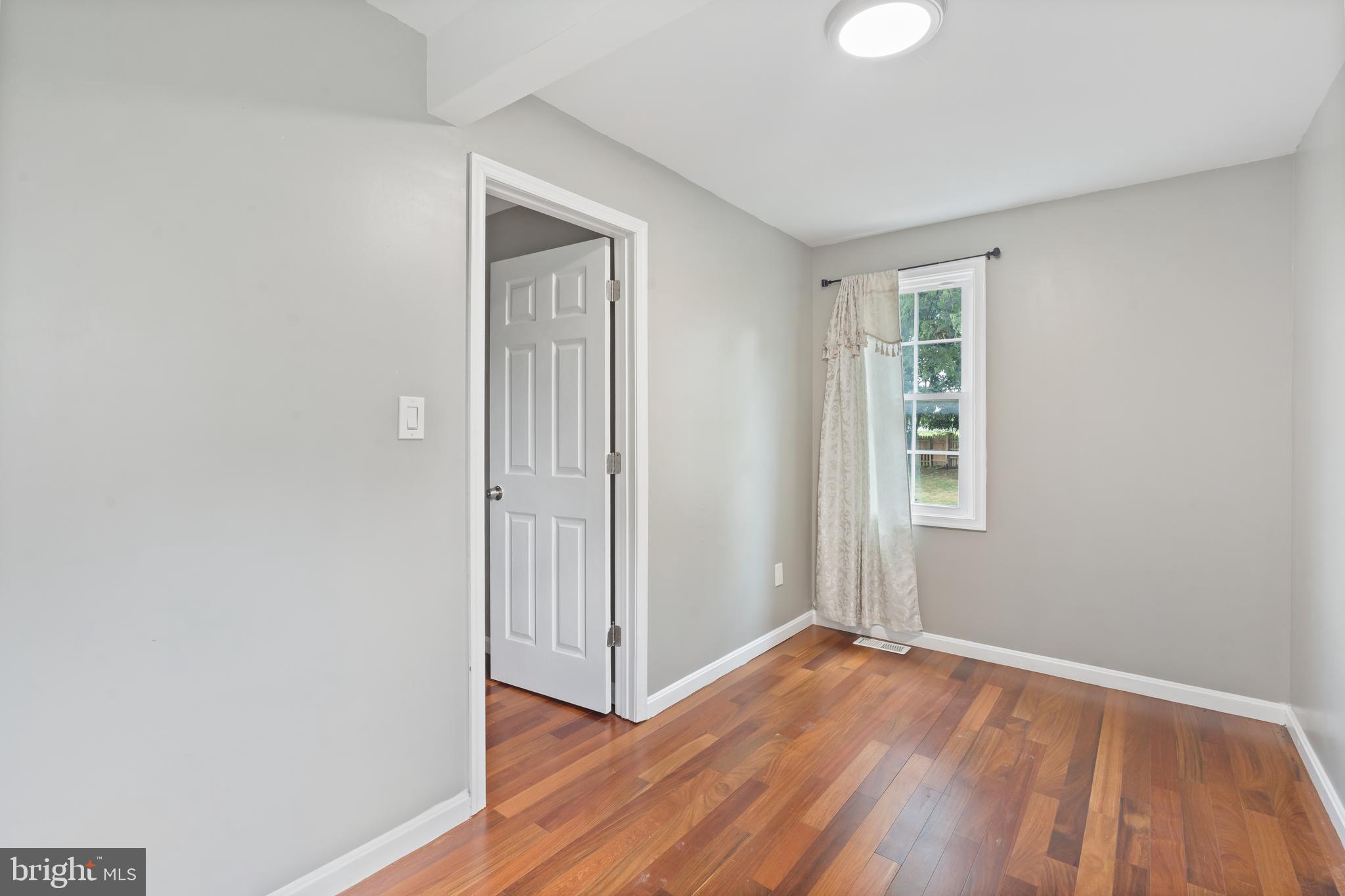 4400 6th Street Baltimore, MD 21225 - Photo 18 of 45 an empty room with wooden floor and windows