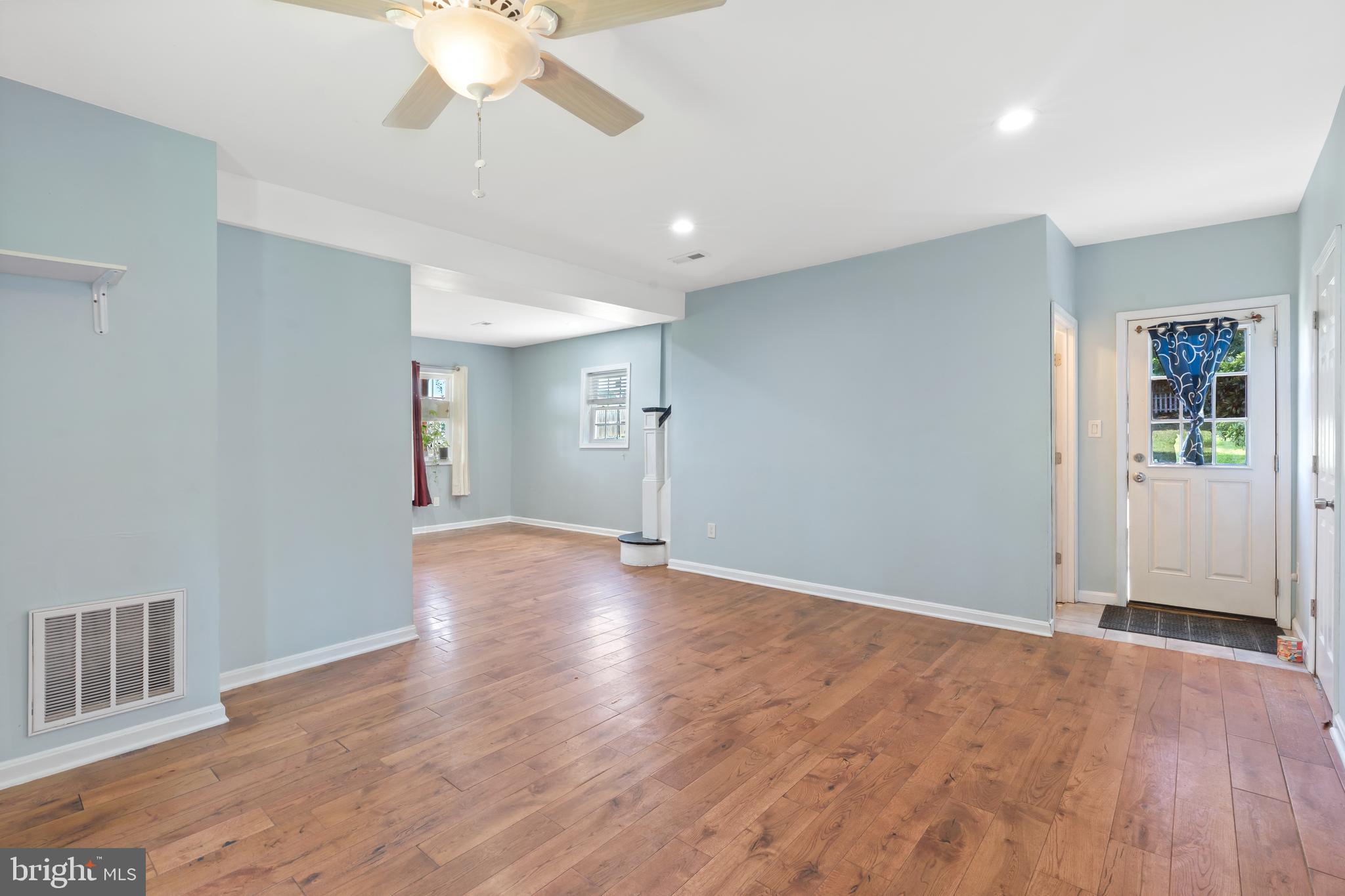 4400 6th Street Baltimore, MD 21225 - Photo 26 of 45 a view of an empty room with wooden floor and a ceiling fan