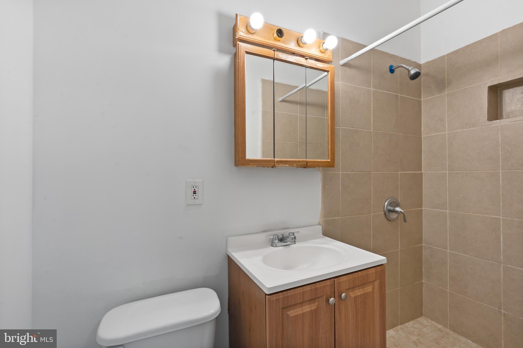 4400 6th Street Baltimore, MD 21225 - Photo 34 of 45 a bathroom with a toilet sink and mirror