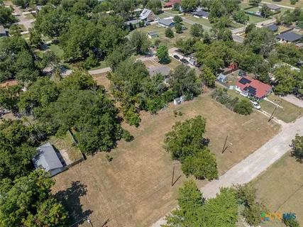 an aerial view of a house with a yard and lake view