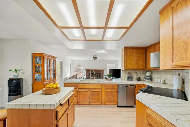 a kitchen with stainless steel appliances kitchen island wooden cabinets a sink and a stove