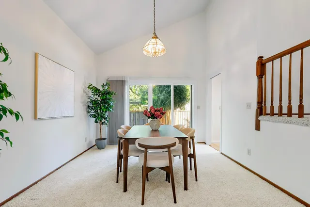 a dining room with furniture potted plants and wooden floor
