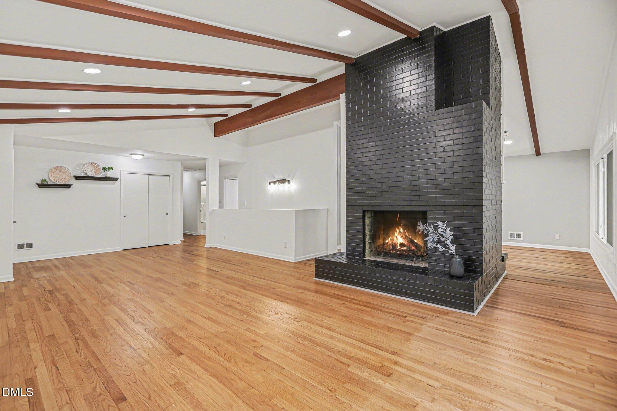 2600 Wade Avenue Raleigh, NC 27607 - Photo 5 of 31 a view of an empty room with wooden floor fireplace and a window