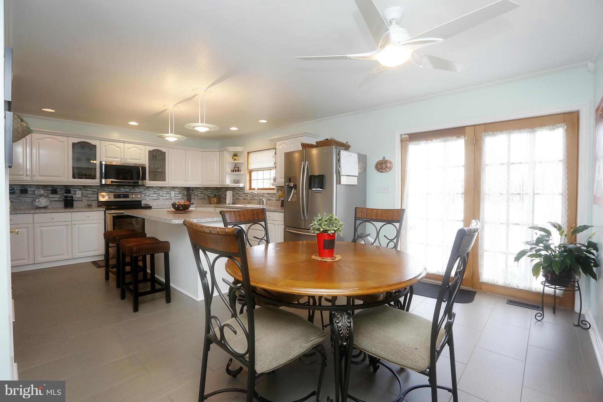 4609 Forge Road Perry Hall, MD 21128 - Photo 14 of 30 a kitchen with kitchen island a dining table and chairs