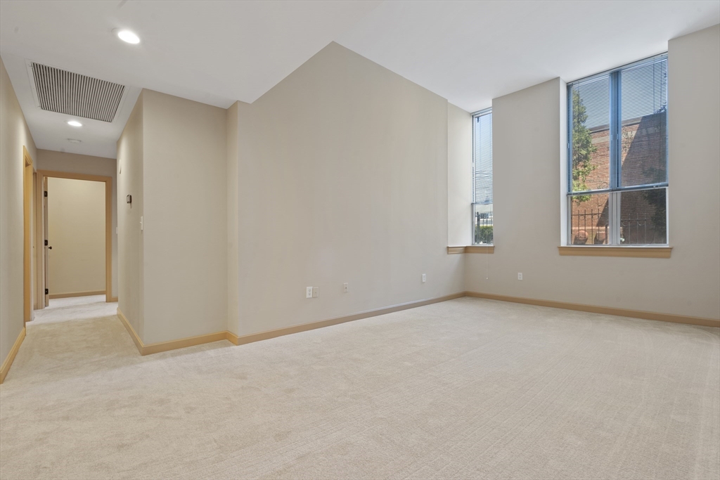 550 Washington Street, Unit 107 Braintree, MA 02184 - Photo 3 of 8 an empty room with windows and closet