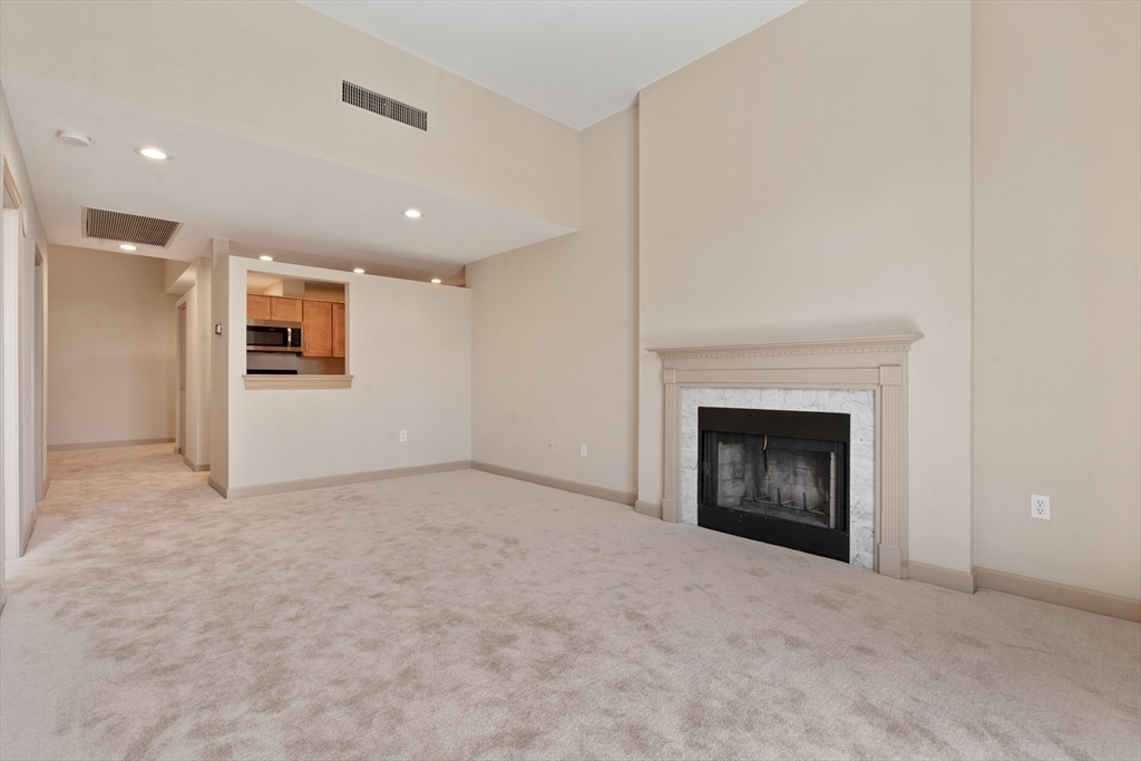 550 Washington Street, Unit 107 Braintree, MA 02184 - Photo 6 of 8 a view of an empty room with a fireplace