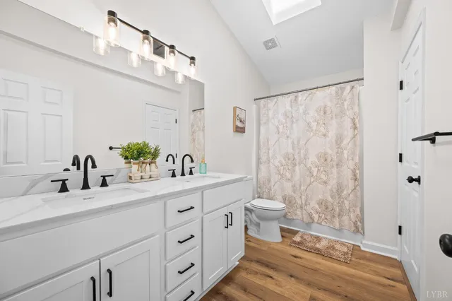 a bathroom with a double vanity sink toilet and shower
