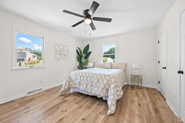 a bedroom with a bed and wooden floor
