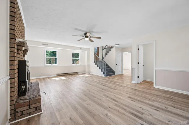 a view of a livingroom with wooden floor and stairs