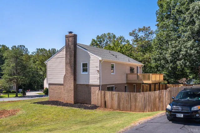a view of a house with backyard and trees