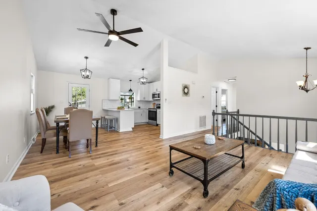 a living room with furniture a rug and a ceiling fan