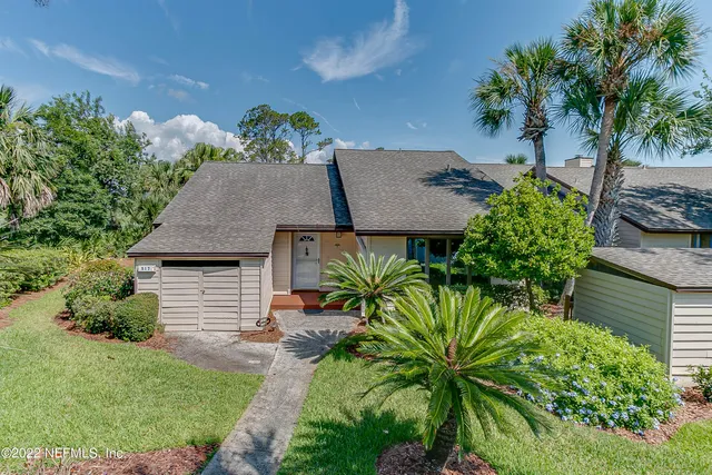 a view of a house with a yard and potted plants