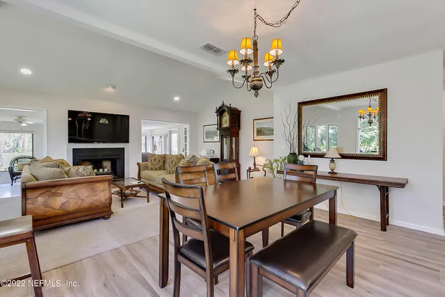 a view of a dining room with furniture a chandelier and wooden floor
