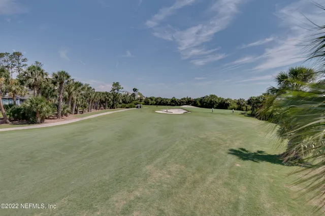 a sign that is sitting in front of a tree