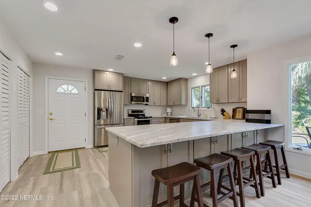 a large kitchen with kitchen island a table and chairs in it