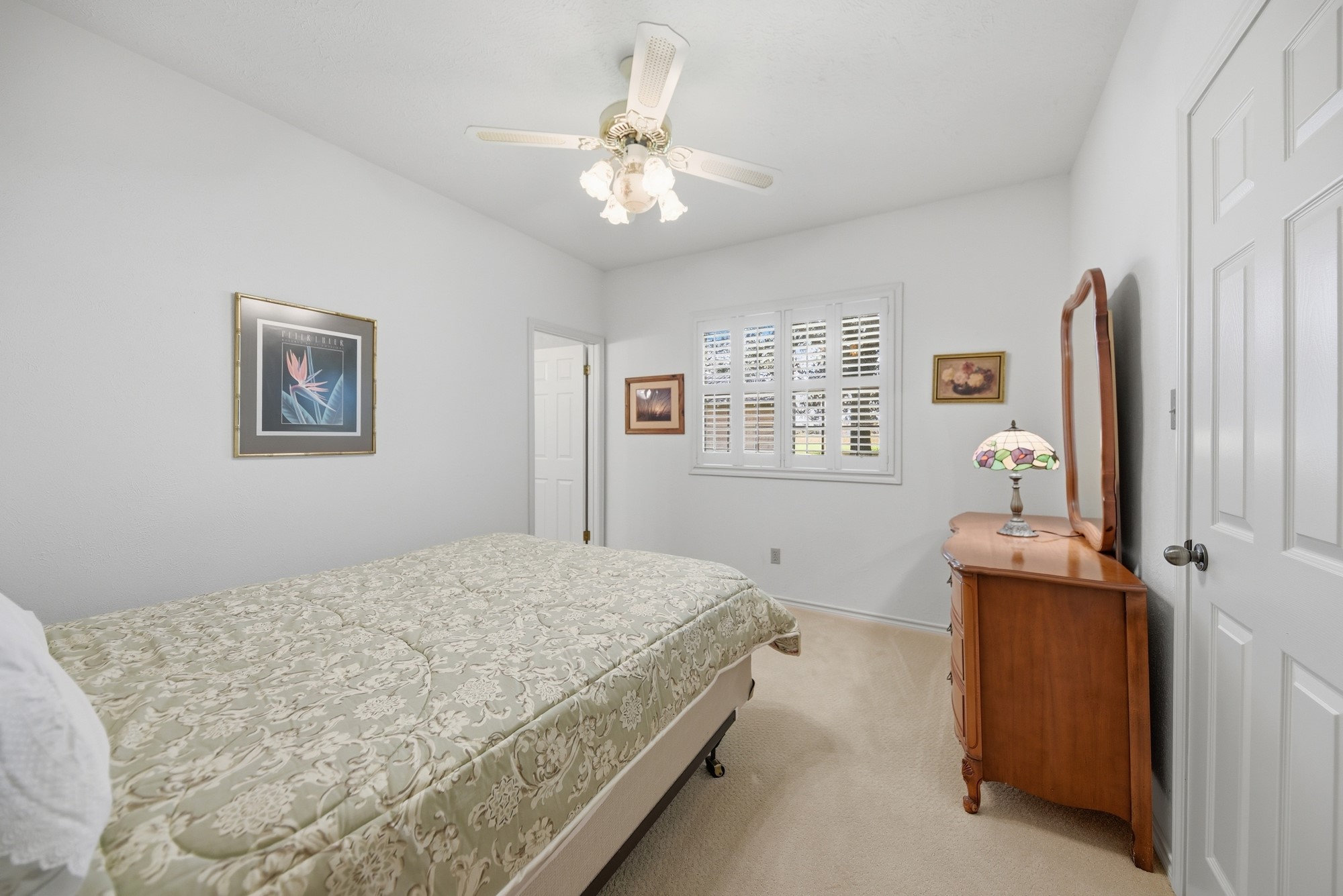 1552 Holub Road Schulenburg, TX 78956 - Photo 30 of 35 A comfortable bedroom features carpet flooring, a ceiling fan, and window shutters, creating a cozy and functional living space.