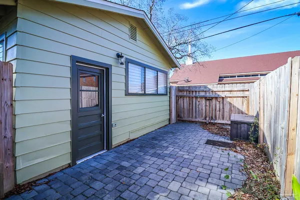 a view of a house with a small yard and wooden fence