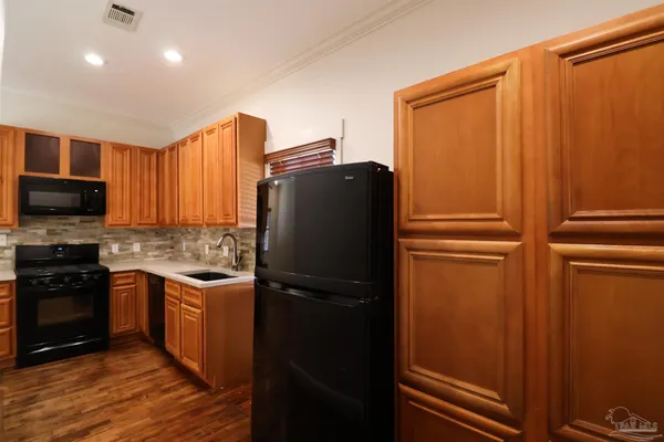 a kitchen with a refrigerator and a stove top oven