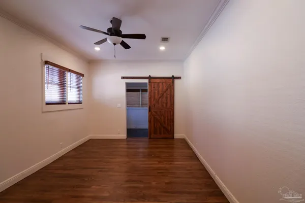 a view of empty room with wooden floor