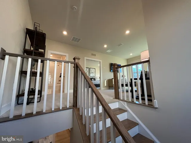 a view of staircase with lots of frames on wall and a window