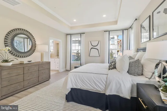 a bedroom with a large bed and a chandelier