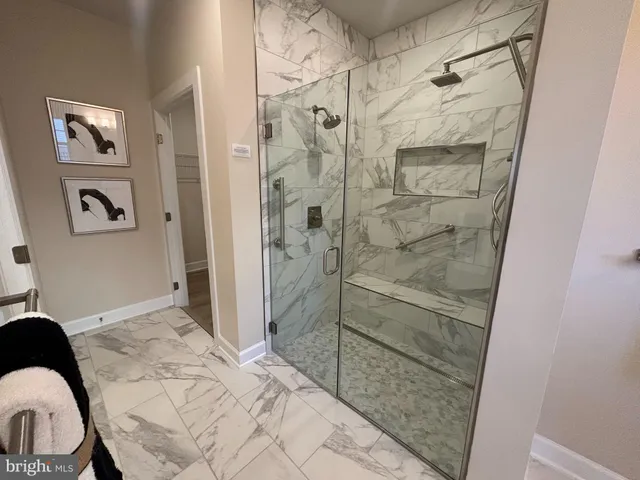 a bathroom with a granite countertop shower a mirror and a sink