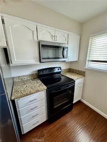 a kitchen with granite countertop stainless steel appliances and wooden cabinets
