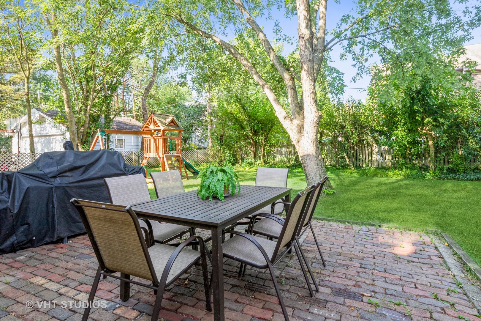 932 Echo Lane Glenview, IL 60025 - Photo 14 of 18 a view of a backyard with table and chairs potted plants and a large tree