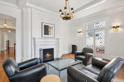 a view of a livingroom with furniture wooden floor windows and a chandelier
