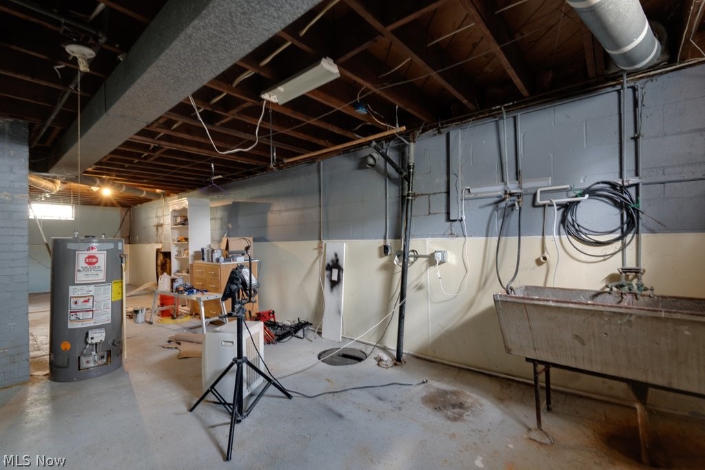3569 Elm Road Stow, OH 44224 - Photo 14 of 17 Expansive unfinished lower level featuring exposed ceiling joists, a utility sink, and visible water heater