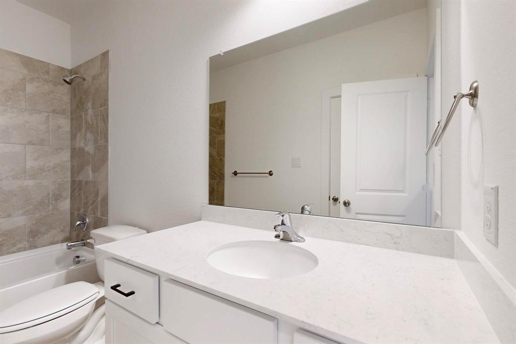 1520 Solterra Boulevard Mesquite, TX 75181 - Photo 11 of 22 a bathroom with a sink toilet vanity and shower