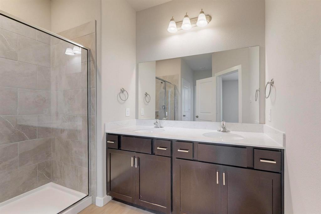 1520 Solterra Boulevard Mesquite, TX 75181 - Photo 13 of 22 a bathroom with a double vanity sink mirror and shower