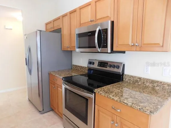 a kitchen with stainless steel appliances granite countertop a stove microwave and refrigerator