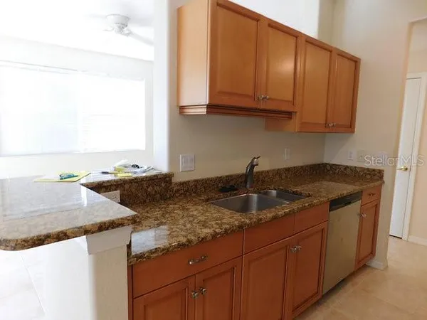 a kitchen with granite countertop a sink and a stove