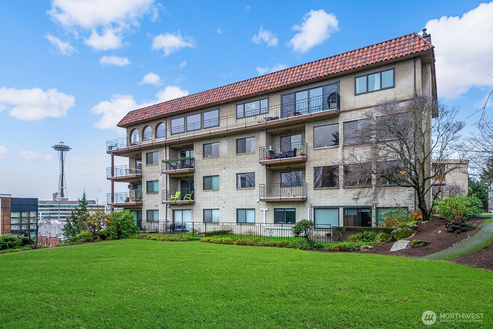 610 Aloha Street, Unit 404 Seattle, WA 98109 - Photo 1 of 23 a front view of a building with a garden