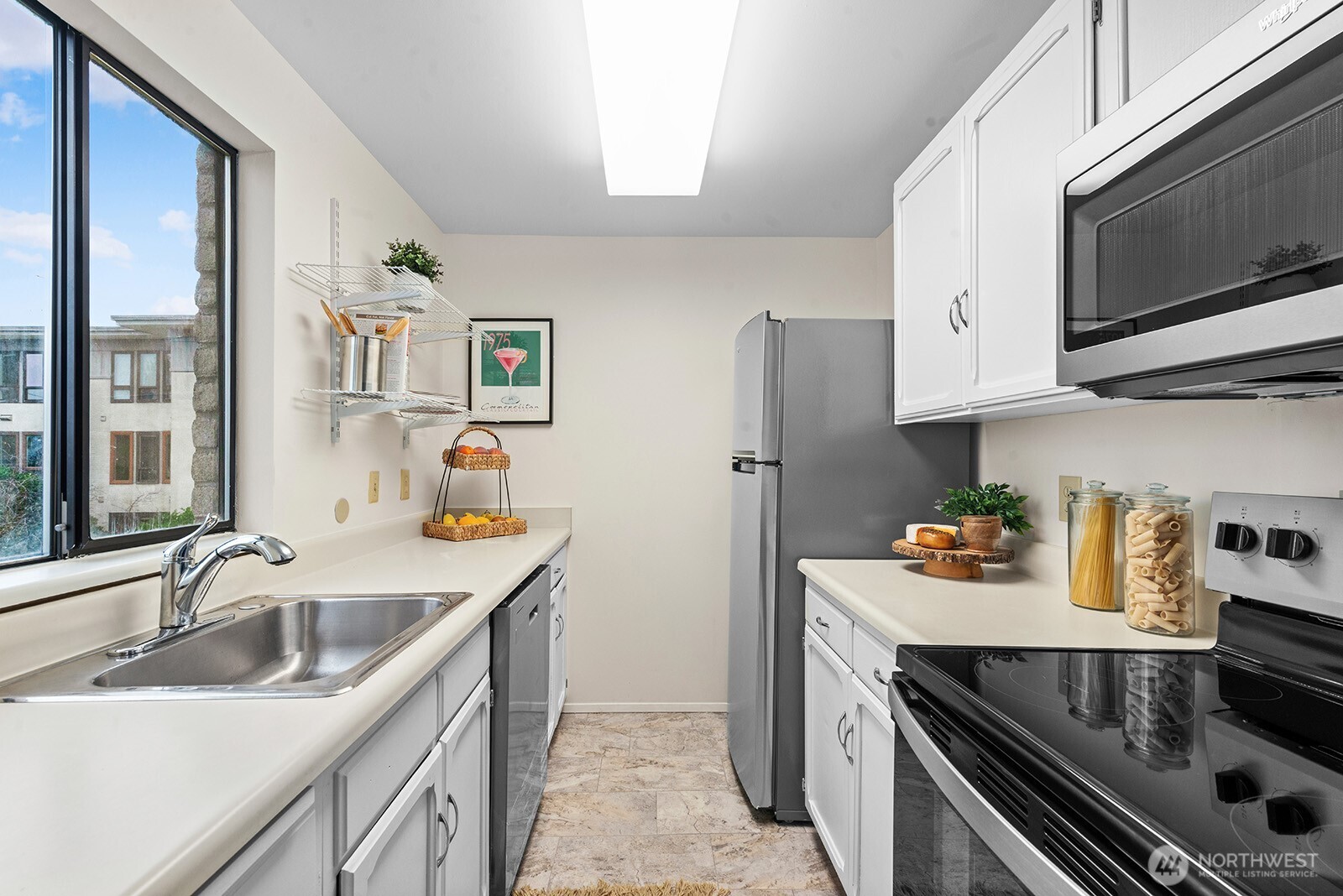 610 Aloha Street, Unit 404 Seattle, WA 98109 - Photo 14 of 23 a kitchen with stainless steel appliances granite countertop a sink stove and refrigerator