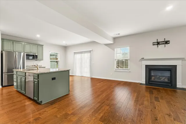 a kitchen with stainless steel appliances a stove top oven a refrigerator a sink and a fireplace